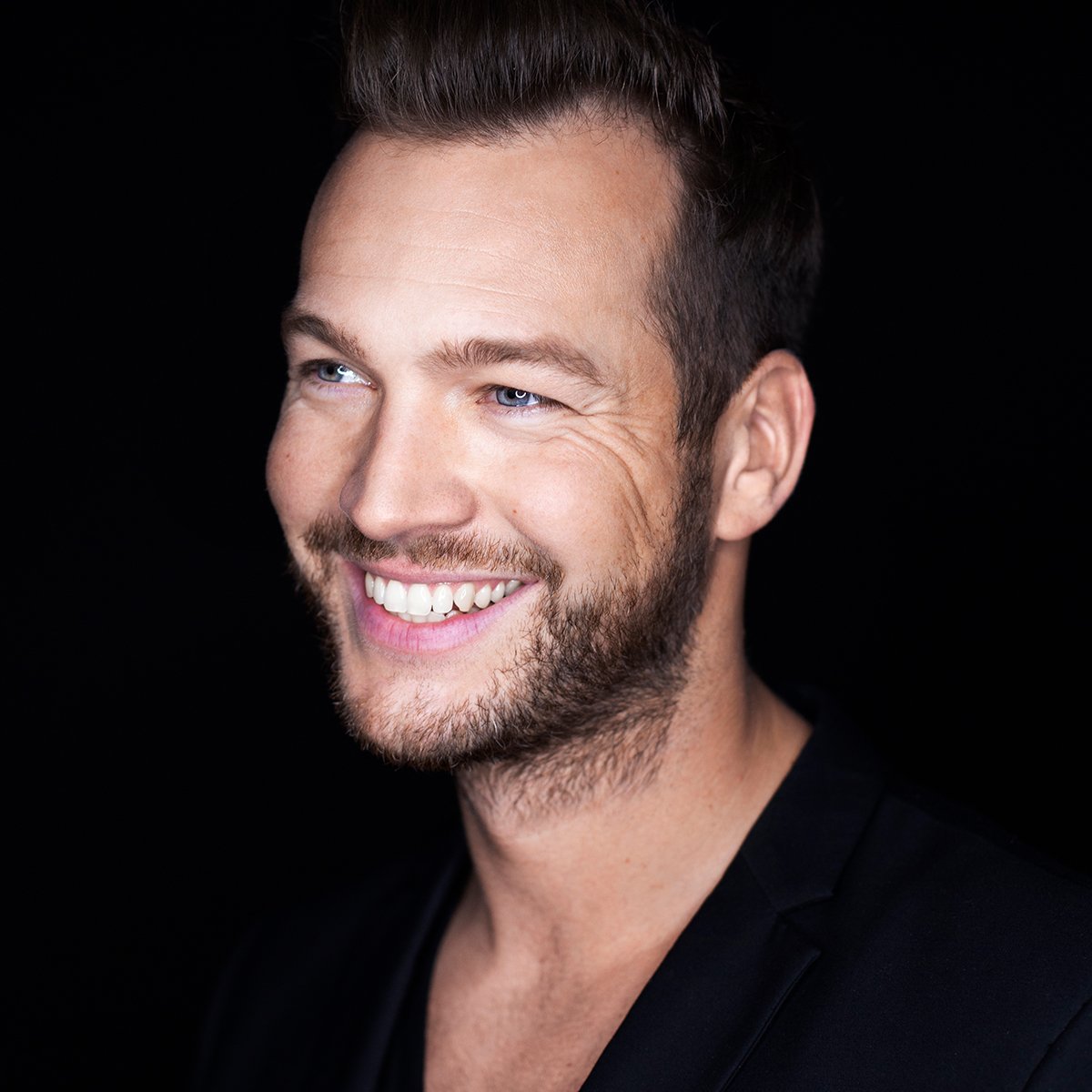 Studio-Porträt von Marvin Albrecht vor schwarzem Hintergrund